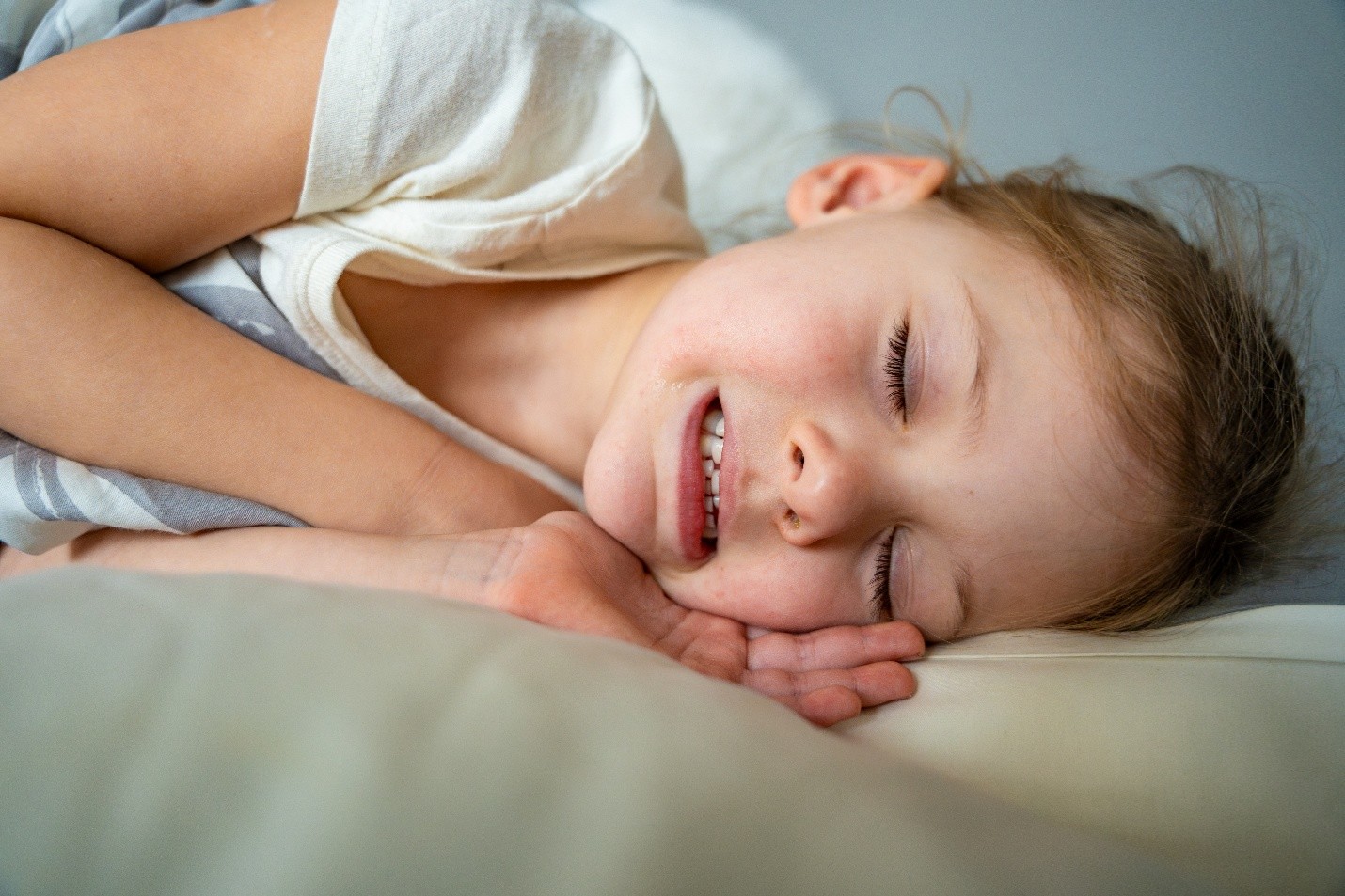 Uma menina criança dormindo rangendo os dentes.